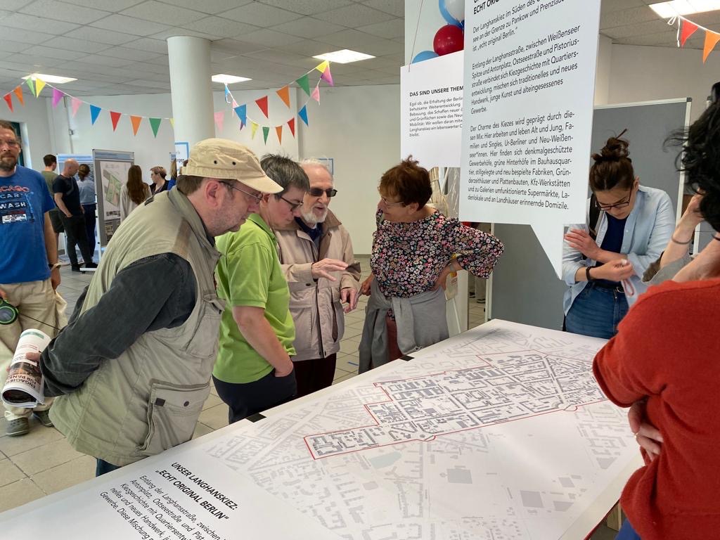 Besucher:innen im Gespräch mit Arno Kiel bei der Ausstellung zum Langhanskiez